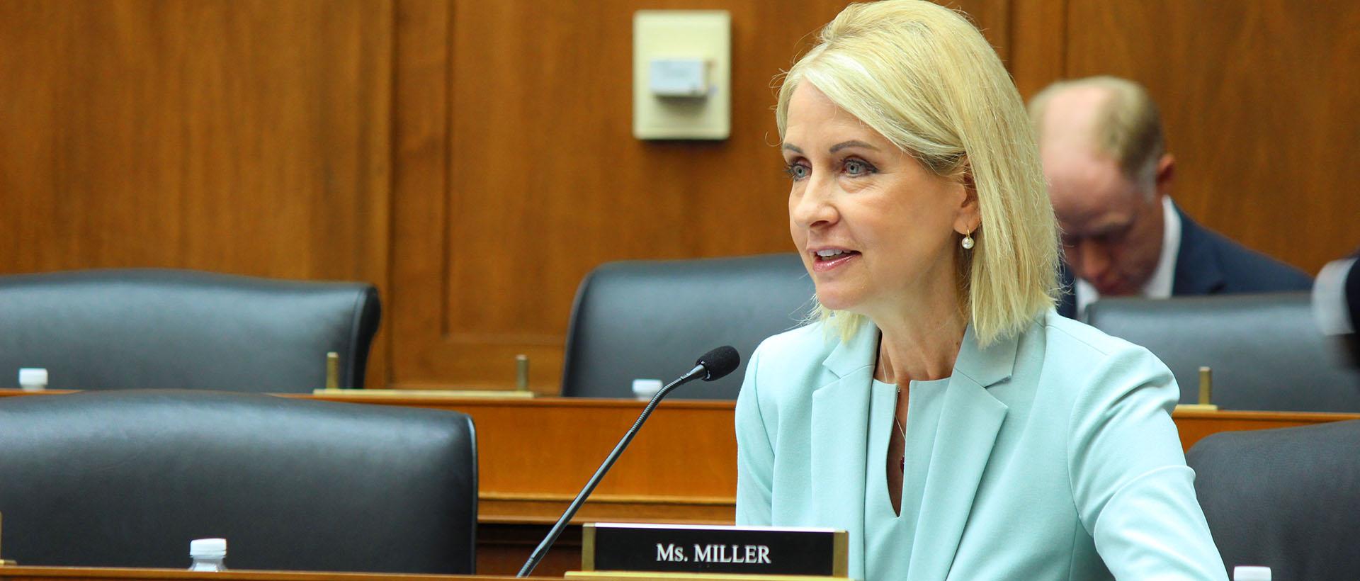 Committee Hearing photo with light blue/aqua jacket