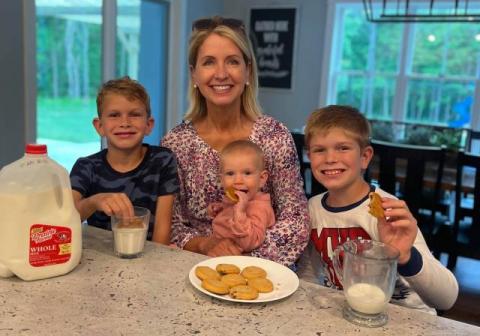 the member and her children enjoying cookies and milk
